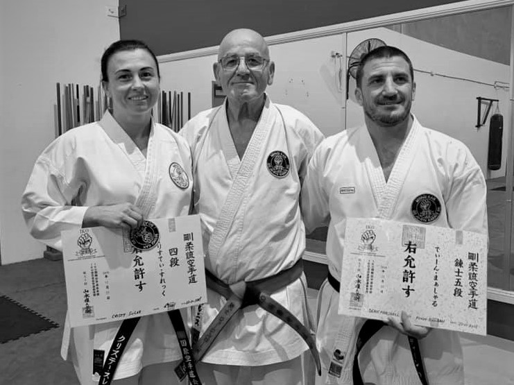Sensei standing with instructors holding dan grading certificates